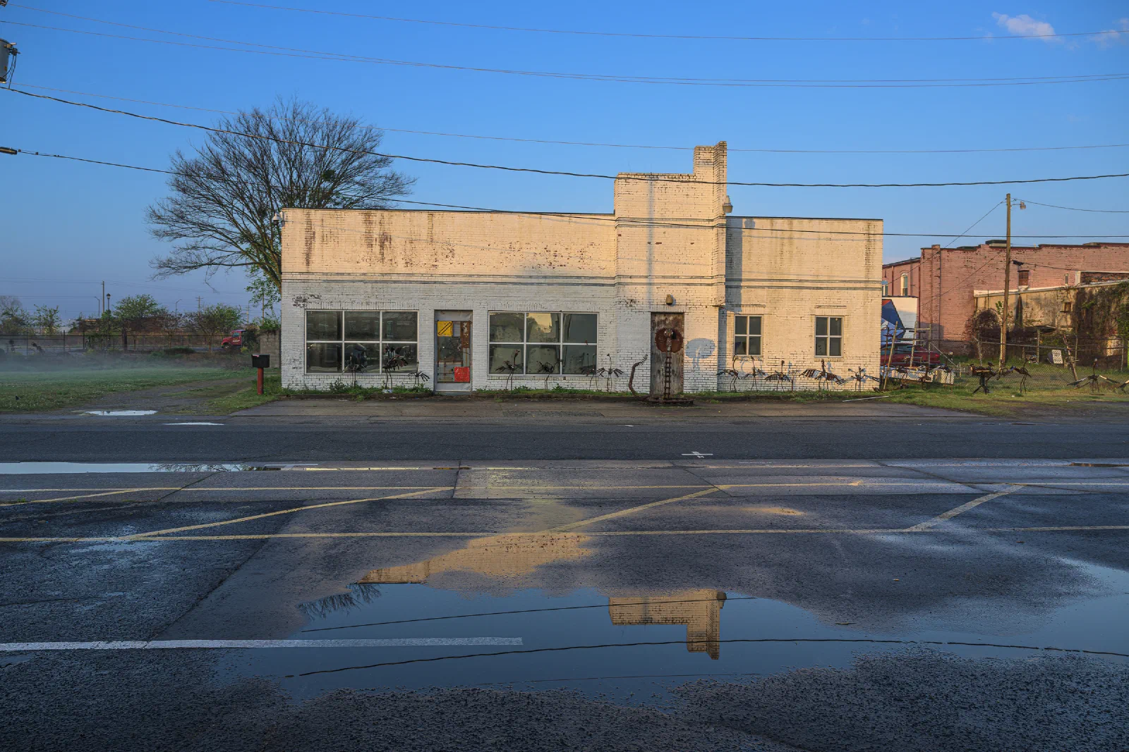 White brick building reflected in a puddle